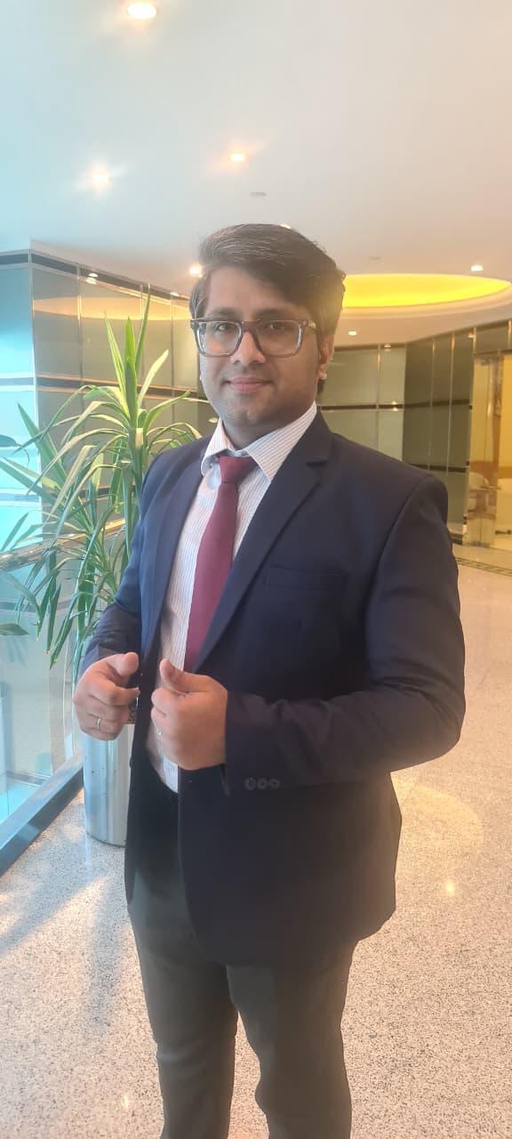 Enson Jose wearing a navy suit in an office setting